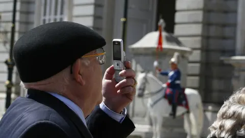 Una persona de la tercera edad hace una fotografía a un monumento