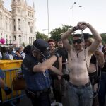 Miembros de la policía municipal registran a las personas que acceden a la Puerta de Alcalá de Madrid, para asistir a los conciertos