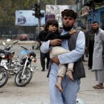 Un padre lleva a su hijo en brazos tras el atentado de Jalalabad
