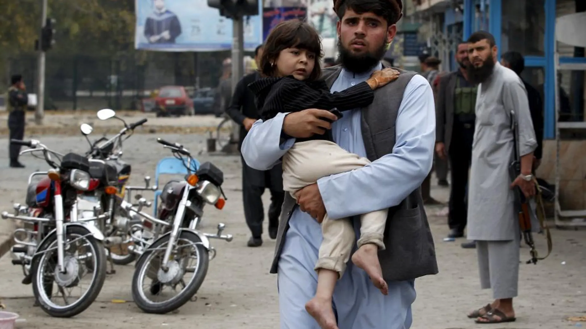 Un padre lleva a su hijo en brazos tras el atentado de Jalalabad