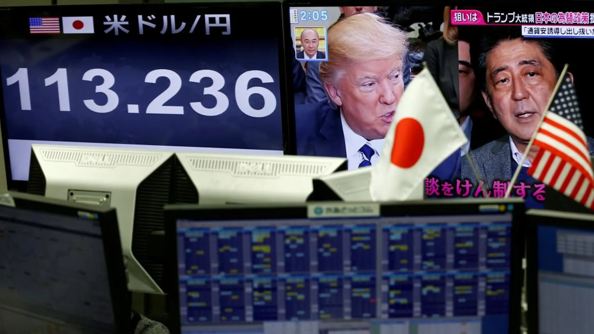 Un monitor de una casa de cambio de moneda muestra las imágenes de Trump y Abe