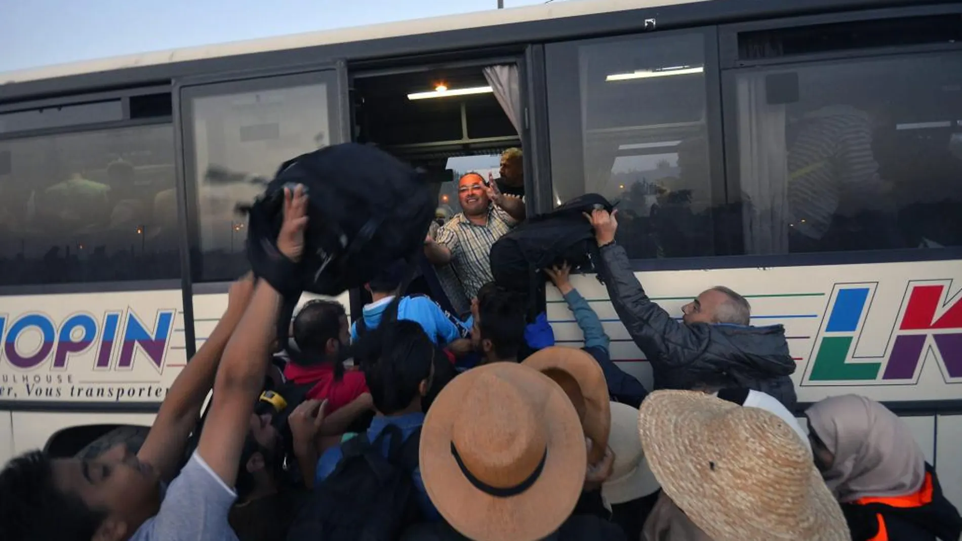 Refugiados intentan subir a un autobús en Serbia, Monday