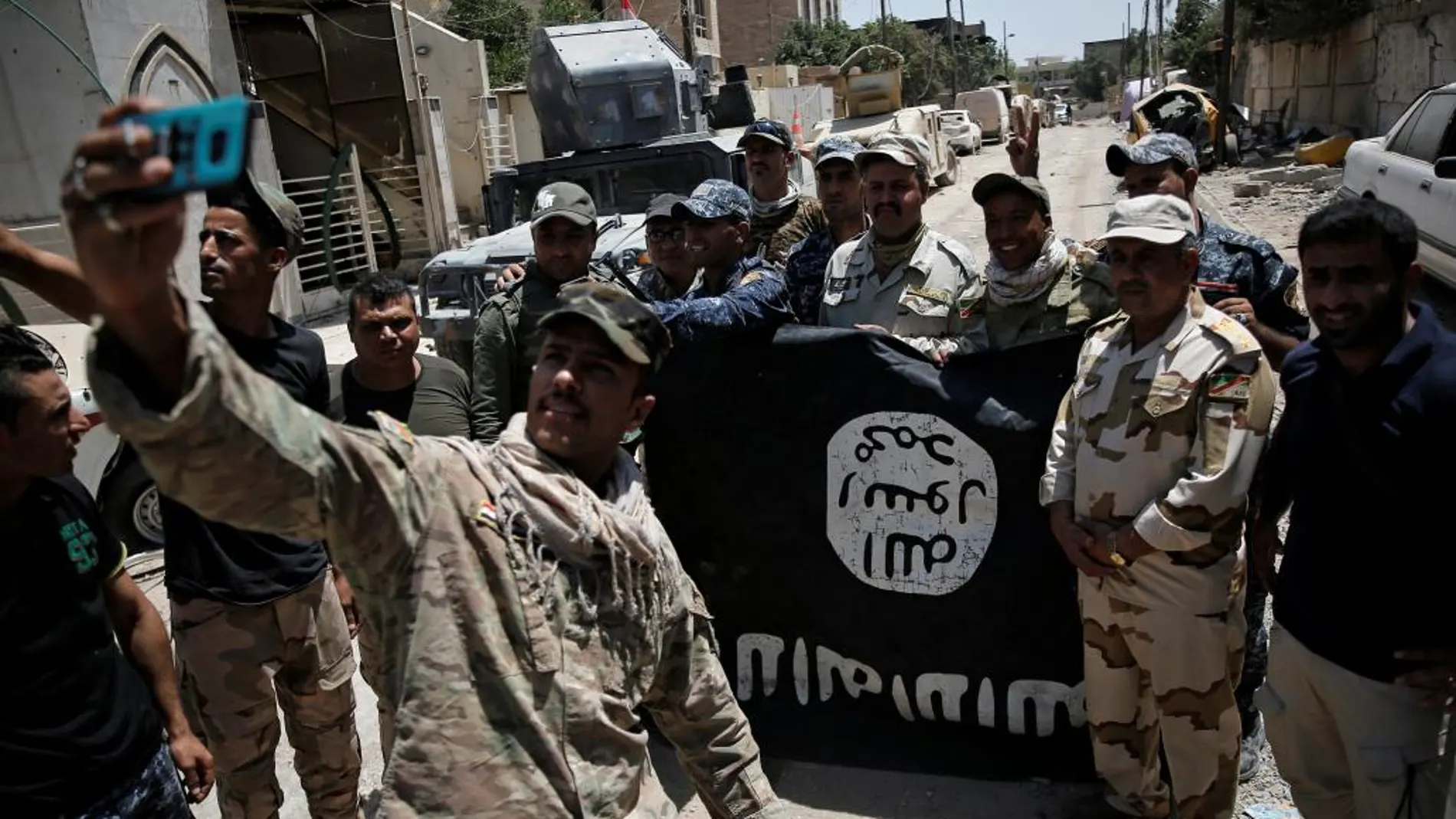 Fuerzas iraquíes se fotografían con la bandera del Estado Islámico