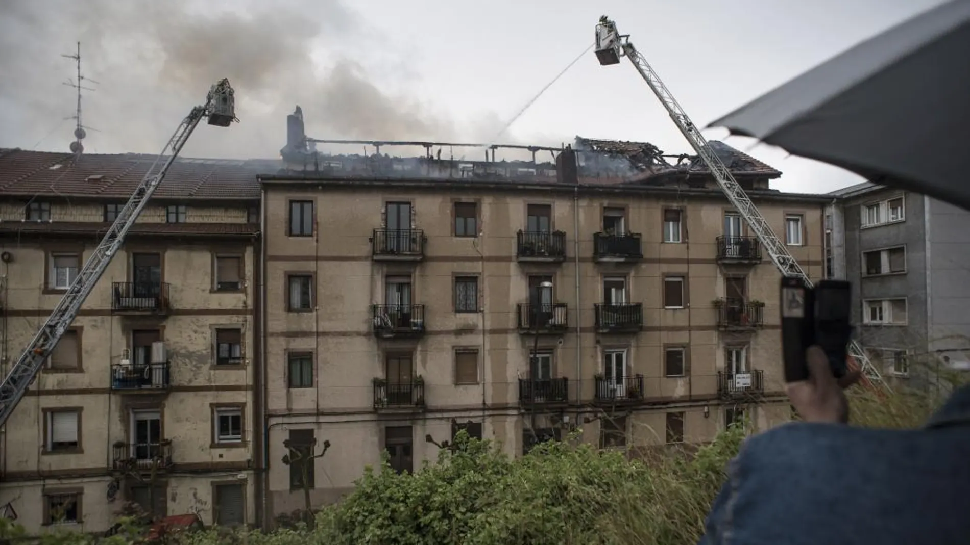 Bomberos trabajan en la extinción del incendio de grandes dimensiones en un edificio de la Gran Vía José Antonio Aguirre, de Sestao