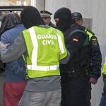 La Guardia Civil introduce en un coche al joven detenido hoy en Santa Coloma de Farners (Girona), un marroquí de 43 años, por financiación del grupo terrorista yihadista Dáesh
