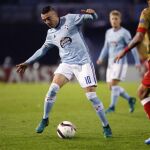 El delantero del Celta de Vigo Iago Aspas (i) con el balón durante el partido de la quinta jornada de Liga Europa que disputan hoy frente al Standard de Lieja en el estadio Balaídos