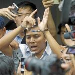 El periodista birmano Kyaw Soe Oo habla ayer con la Prensa mientras es escoltado por la Policía en el tribunal de Rangún