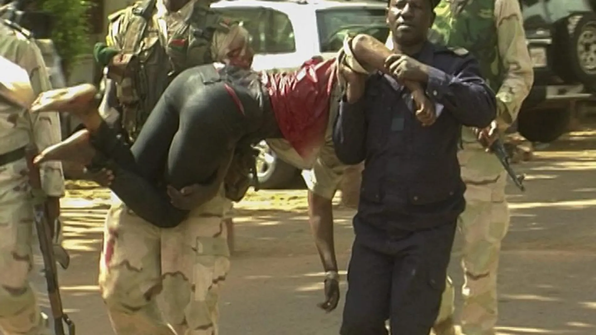 Personal militar de Mali traslada a una mujer herida a su salida del hotel de lujo Radisson Blu en Bamako