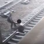 Momento en el que el Policía logra sacar de la vía al suicida