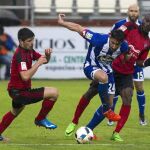 El centrocampista argentino del Deportivo Jonás Gutiérrez lucha por el balón con el defensa Gorka Kijera y el delantero marfileño Lago Júnior, del CD Mirandés