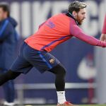 Messi trata de coger un balón con la mano, ayer, en el entrenamiento