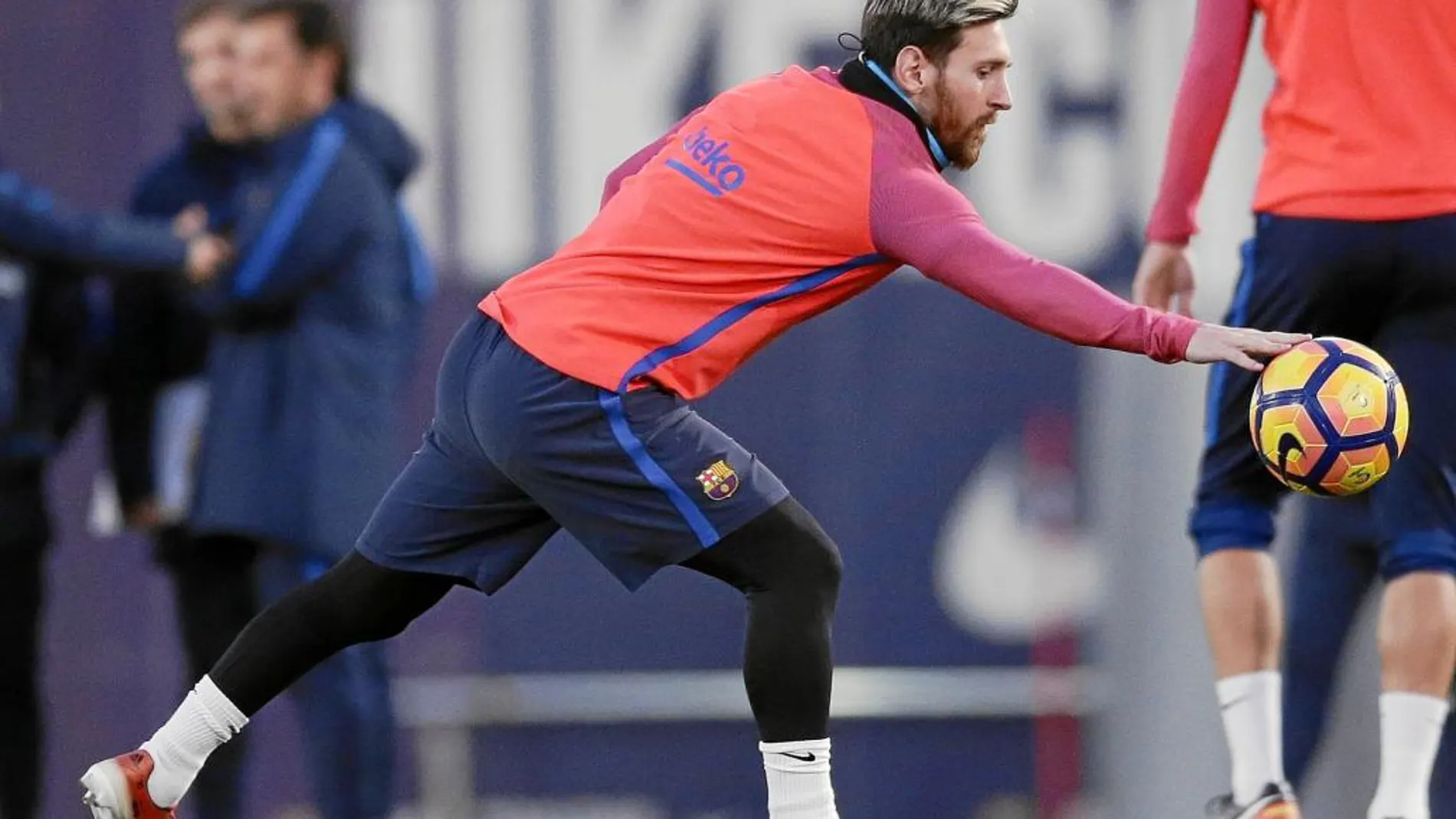 Messi trata de coger un balón con la mano, ayer, en el entrenamiento