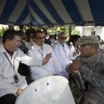 Un soldado estadounidense conversa con médicos cubanos durante un acto celbrado en la base naval de Killick, de Haití, donde atracó un navío hospital de la marina estadounidense