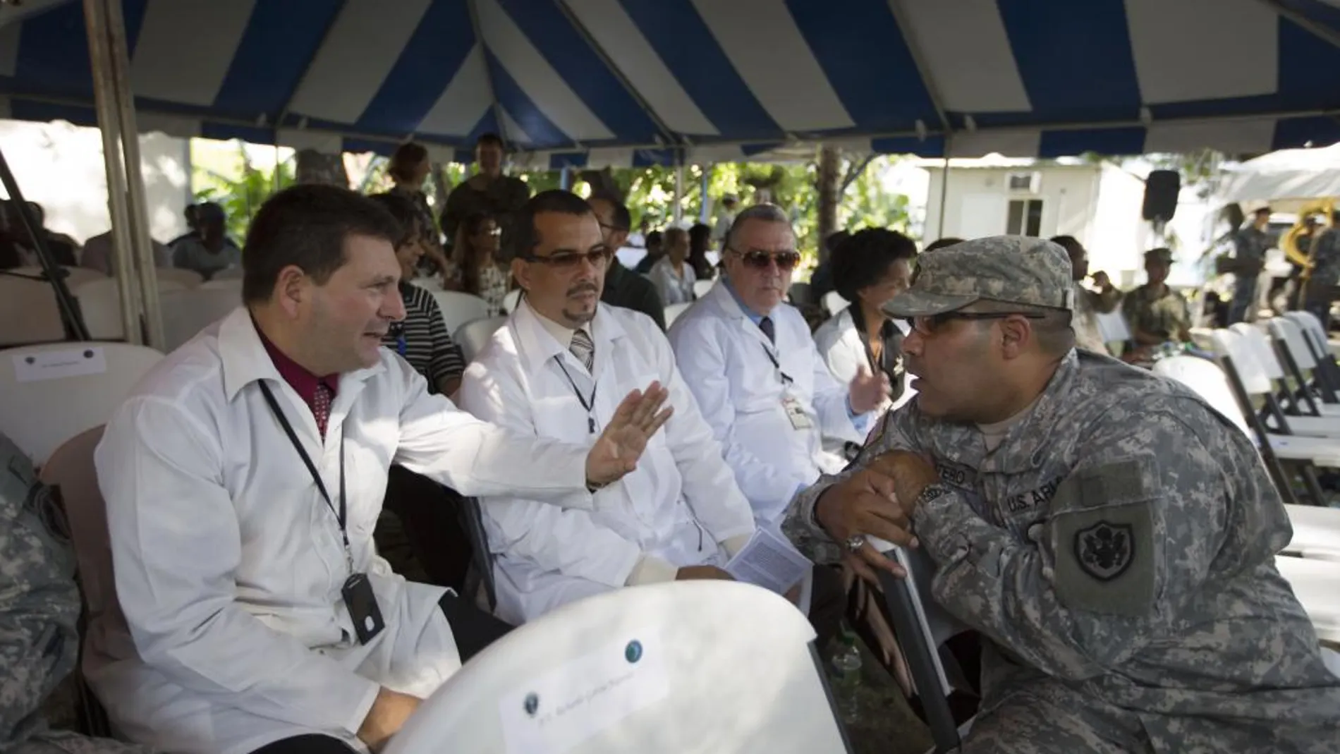 Un soldado estadounidense conversa con médicos cubanos durante un acto celbrado en la base naval de Killick, de Haití, donde atracó un navío hospital de la marina estadounidense