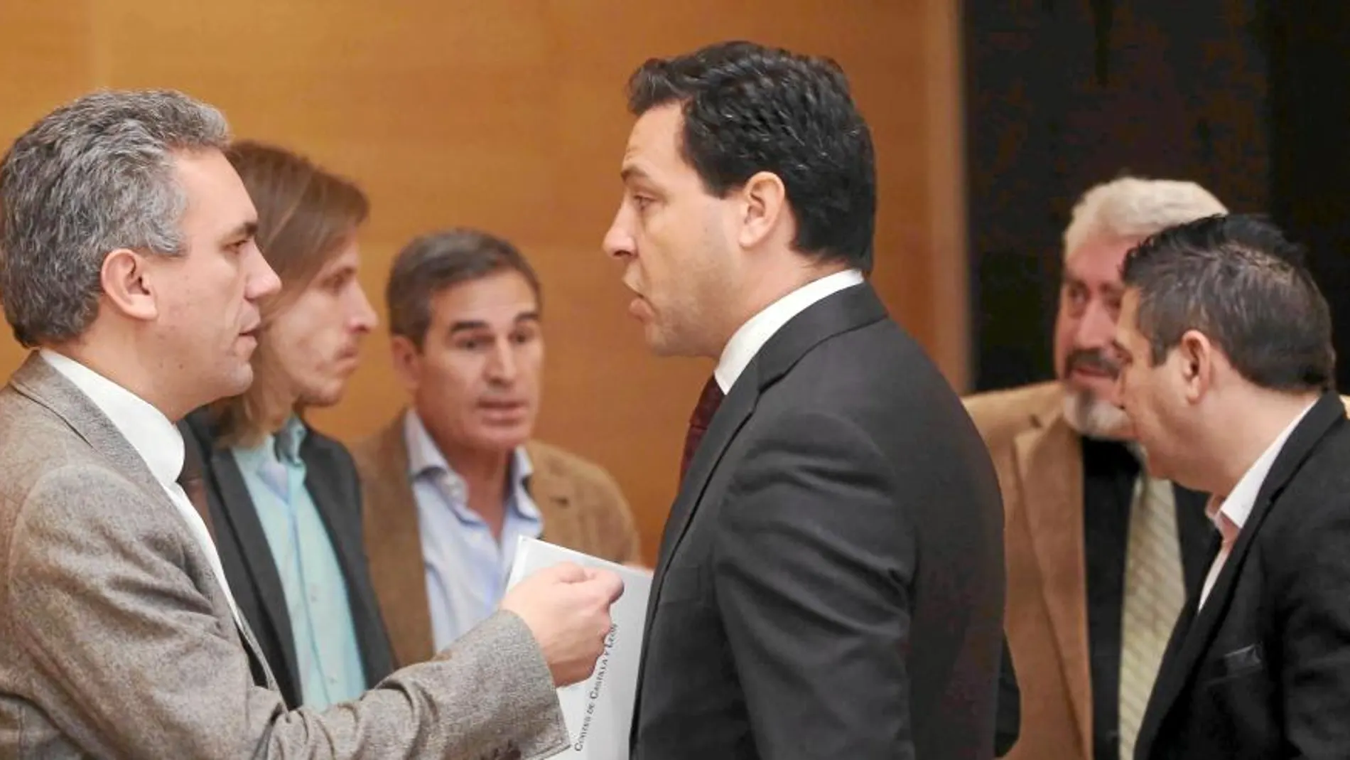 El procurador popular Raúl de la Hoz conversa con el socialista Javier Izquierdo, en presencia de Sanz Vitorio (PP), Pablo Fernández (Podemos), José Ignacio Delgado (Ciudadanos) y Luis Mariano Santos (UPL), tras la reunión de la comisión de investigación de la supuesta trama eólica