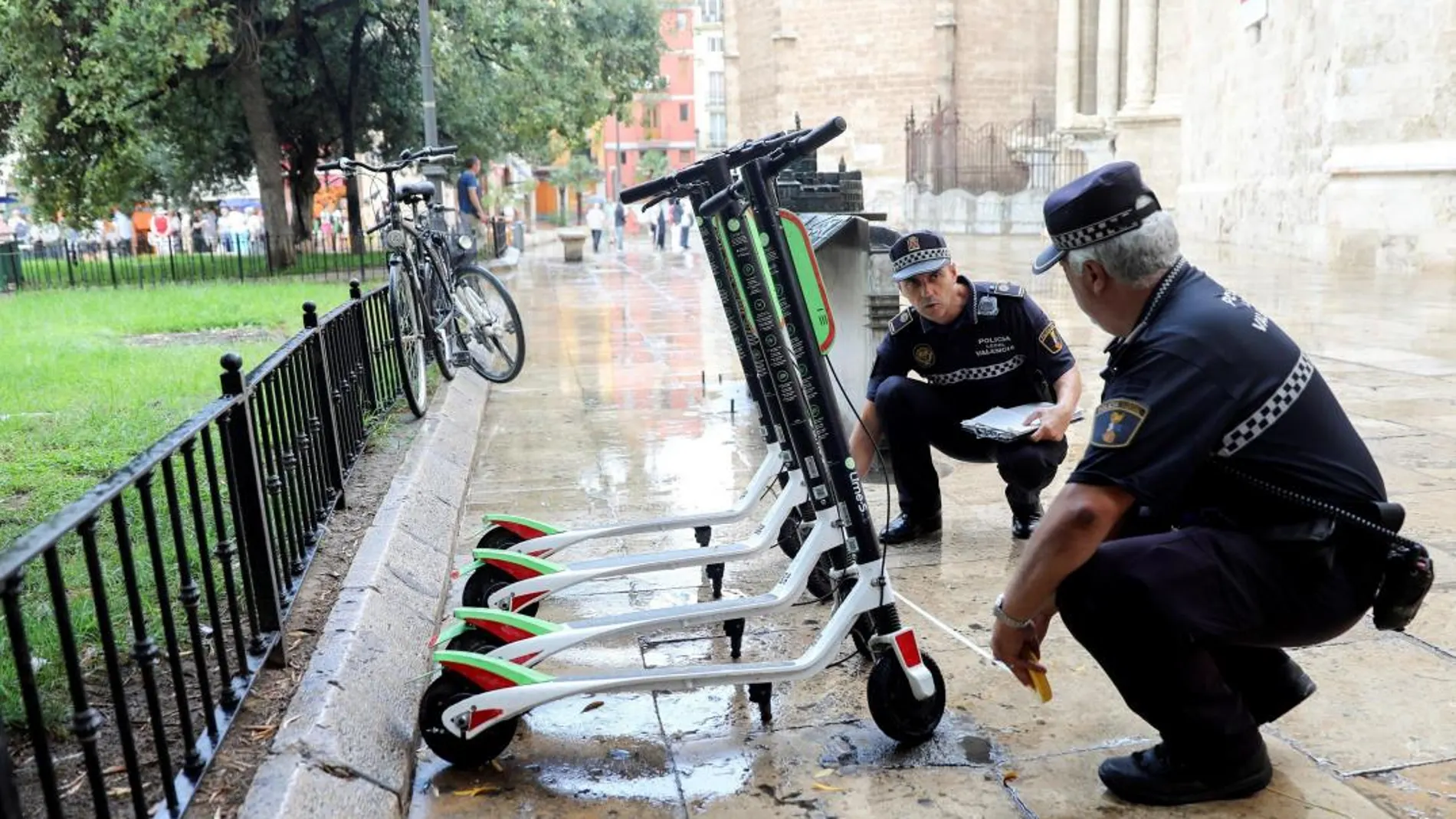 Agentes de la Policía Local de Valencia trabajan en la retirada de los patinetes eléctricos de alquiler. (Efe)