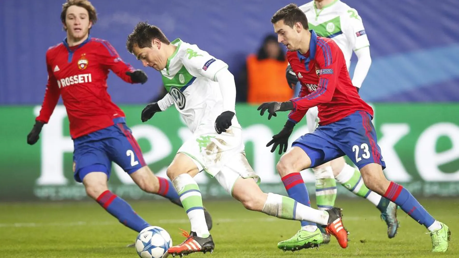 Los jugadores del CSKA de Moscú Mario Fernandes (izda) y Georgi Milanov, pelean por el control del balón con el jugador del Wolfsburgo Marcel Schaefer