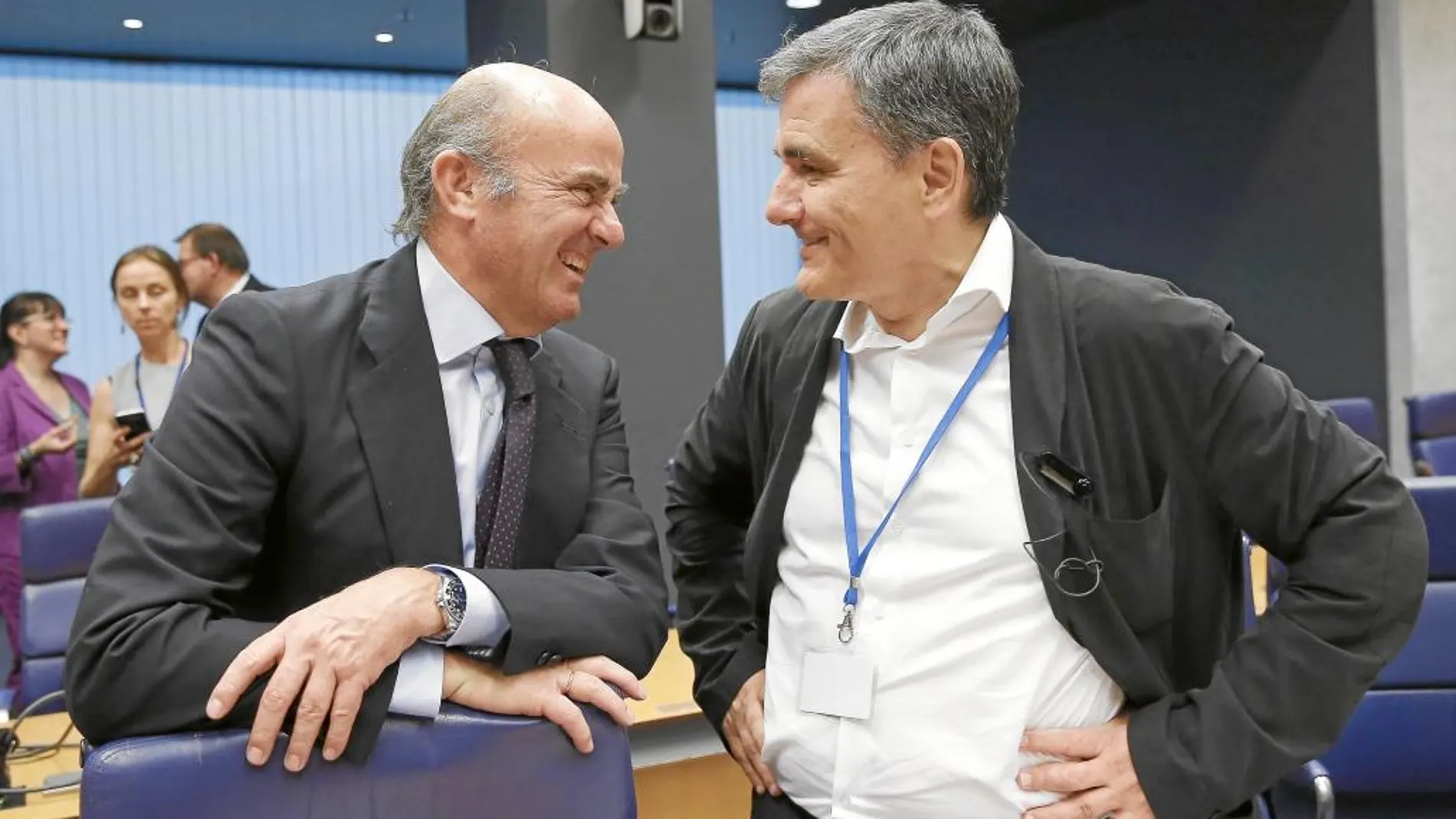 Luis de Guindos, con Euclides Tsakalotos, ayer, en el Eurogrupo