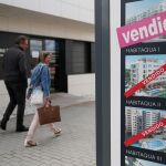 Una pareja pasa junto a una inmobiliaria