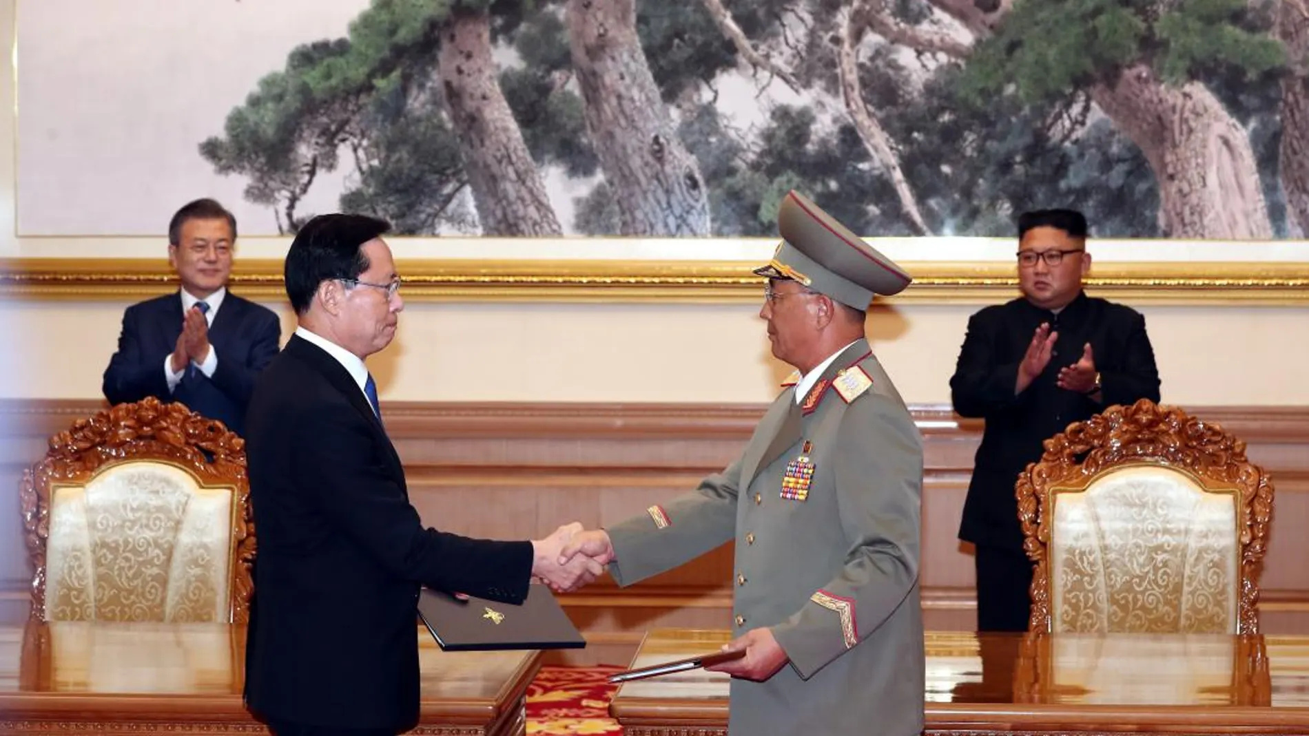 El presidente surcoreano, Moon Jae-in (i, al fondo), y el líder norcoreano, Kim Jong-un (d, al fondo), observan el intercambio de documentos entre el ministro surcoreano de Defensa, Song Young-moo (i, en primer término), y su homólogo norcoreano, Rho Kwang-chul (d, en primer término). Foto: Efe