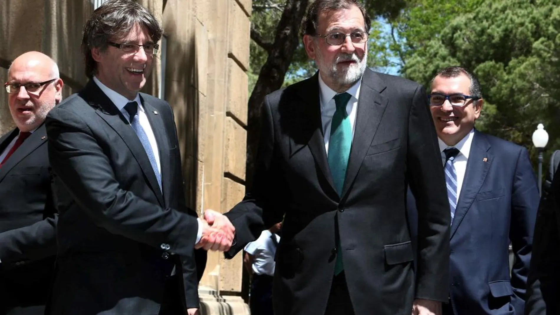 El presidente de la Generalitat, Carles Puigdemont, y el del Gobierno, Mariano Rajoy, se saludan a su llegada hoy al Museo Nacional de Arte de Cataluña