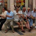 Personas mayores sentadas en la calle malagueña del Marques de Larios.