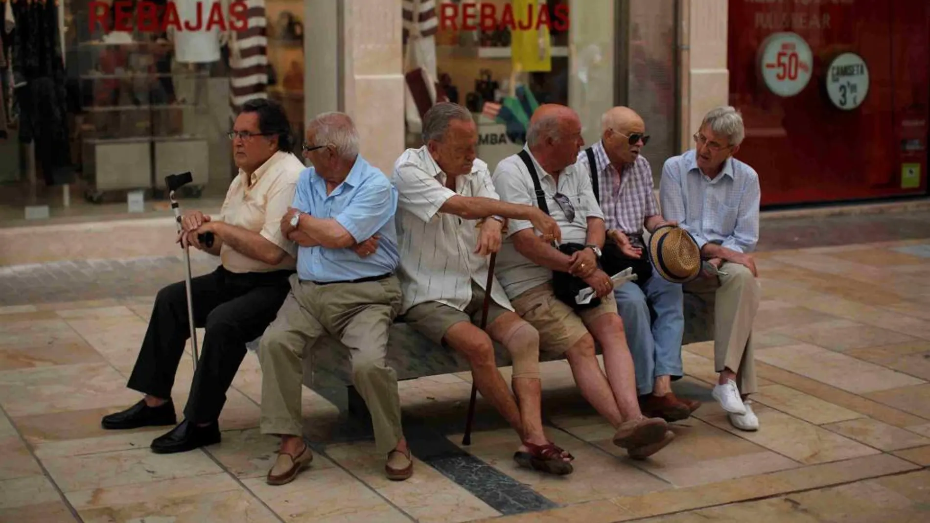 Personas mayores sentadas en la calle malagueña del Marques de Larios.
