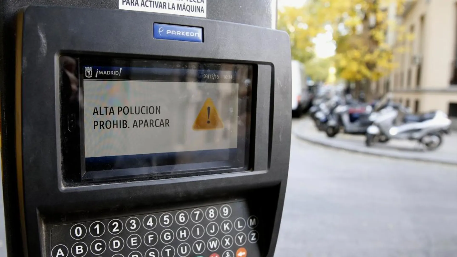 Detalle de la pantalla de un parquímetro que anuncia la prohibición de aparcar por alta polución.