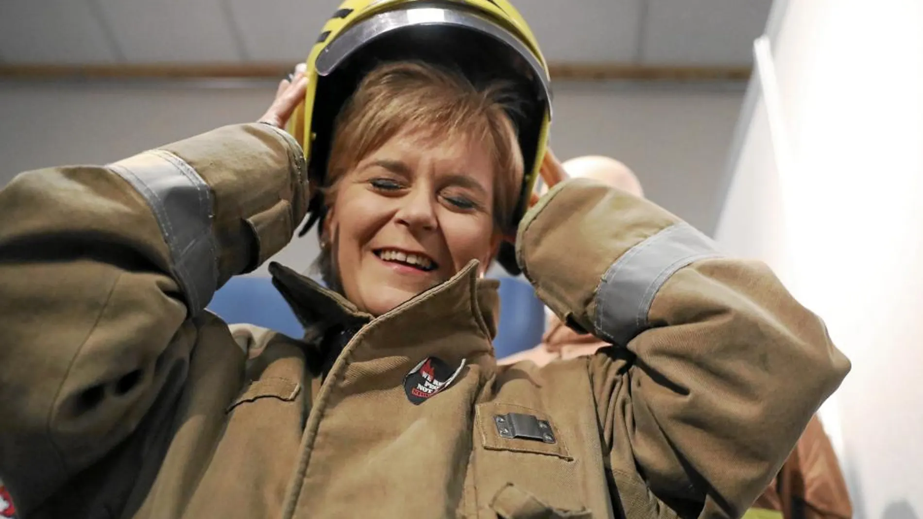 La primera ministra escocesa, Nicola Sturgeon, se prueba el uniforme de los bomberos, ayer en Aberdeen