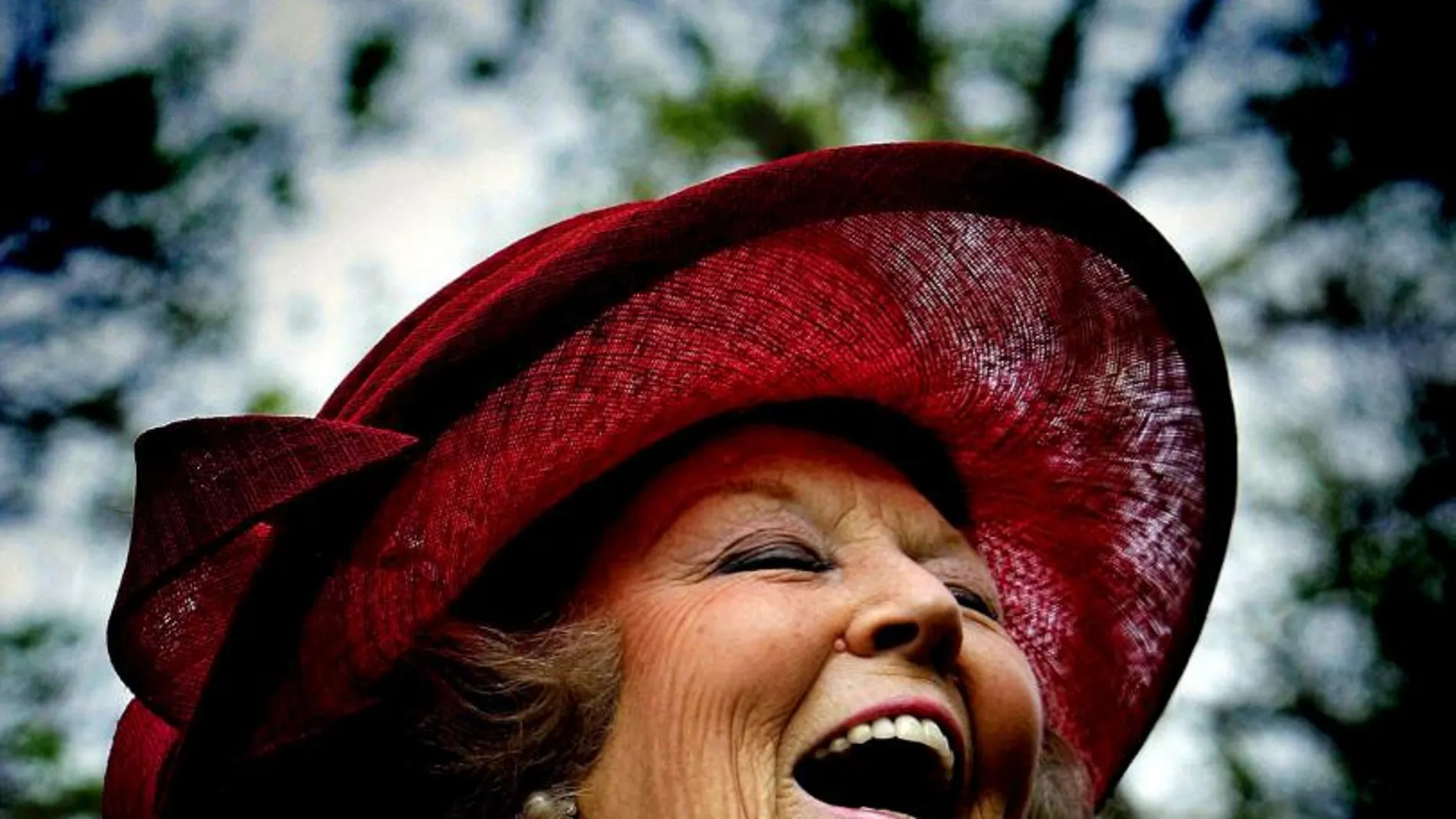 La felicidad es muy saludable, pero no hace vivir más a las mujeres, según un reciente estudio. En la imagen de archivo, la reina Beatriz de Holanda riéndose a carcajadas