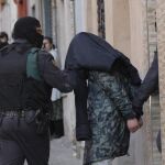Agentes de la Guardia Civil custodian a uno de los dos ciudadanos marroquíes detenidos ayer en Badalona (Barcelona), acusados de realizar actividades de captación, adoctrinamiento y financiación de yihadistas