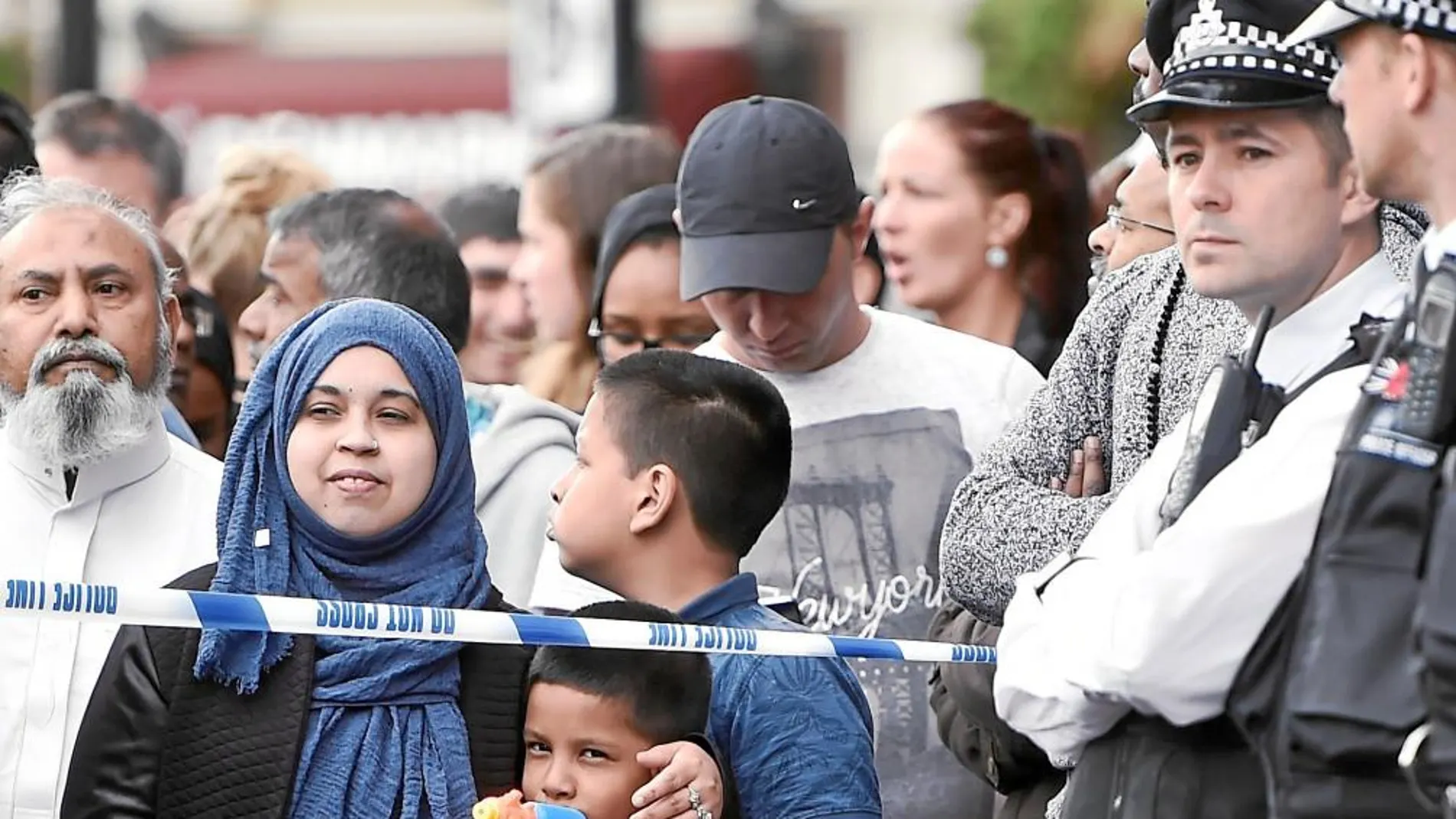 Conmoción entre los británicos: Un niño juega con una pistola de plástico entre los numerosos británicos que ayer se acercaban a la zona del atentado