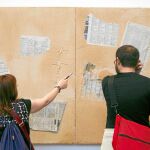 Dos personas ante la obra «Matèria i Diaris», que Tàpies pintó en 2009 y que forma parte de la exposición de 2015