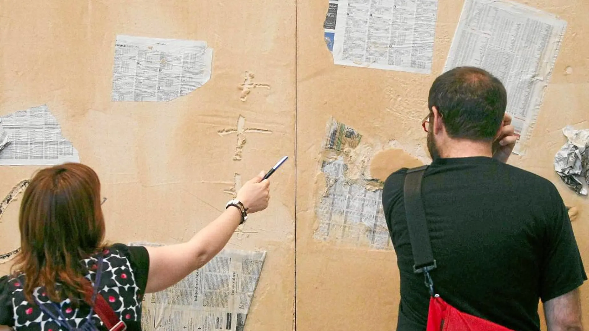 Dos personas ante la obra «Matèria i Diaris», que Tàpies pintó en 2009 y que forma parte de la exposición de 2015