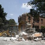 Una excavadora remueve los de un edificio colapsado en Ciudad de México