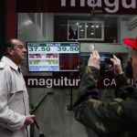 Transeúntes observan y fotografían los paneles de las casas de cambio en el centro de Buenos Aires / Efe