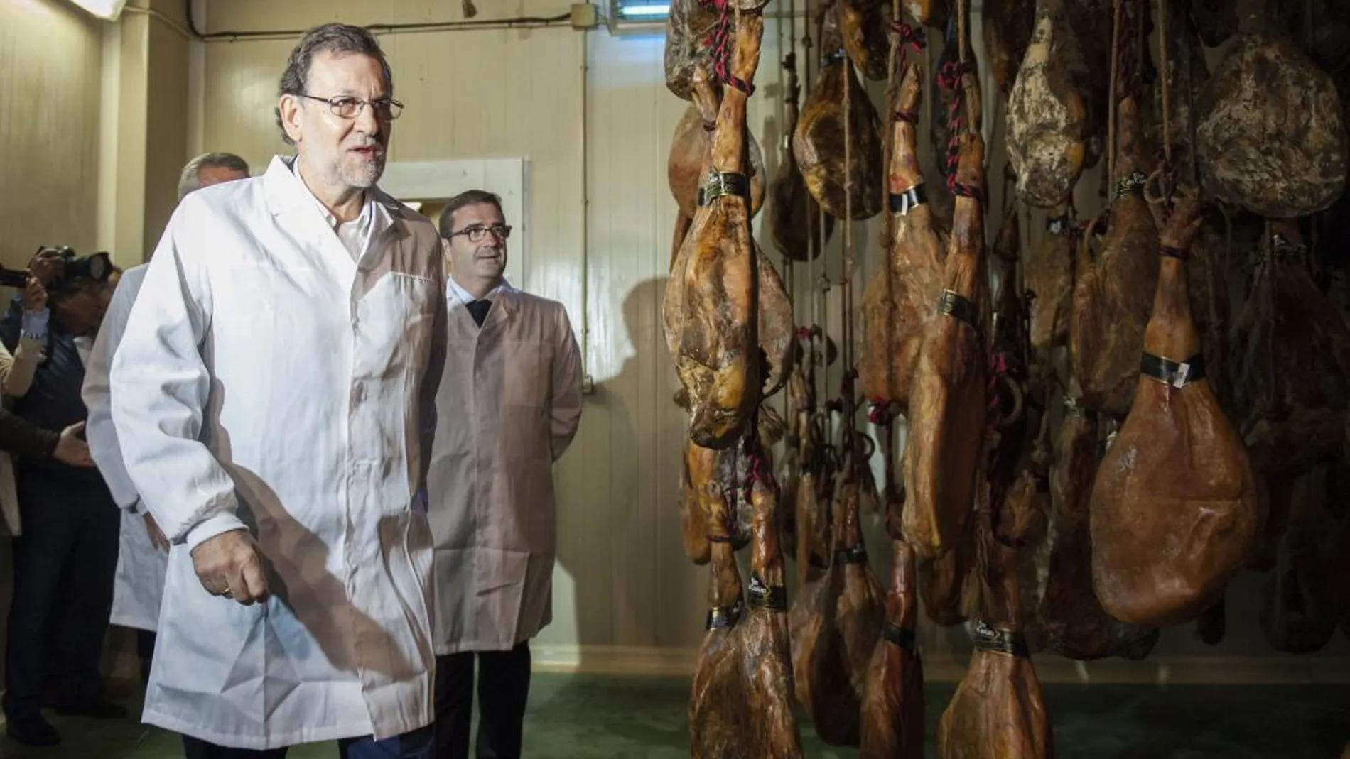 Mariano Rajoy y el alcalde de A Cañiza (Pontevedra), Miguel Domínguez (2i), durante su visita hoy al secadero de jamón del municipio pontevedrés y el Pazo de Mos en el marco de su ronda de visitas de campaña de las elecciones gallegas