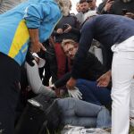 Un hombre atiende a la mujer tras ser golpeada por la bola del jugador americano