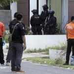 Un escuadrón antiterrorista de la policía indonesia busca alguna evidencia durante una redada en un área residencial en Batam.