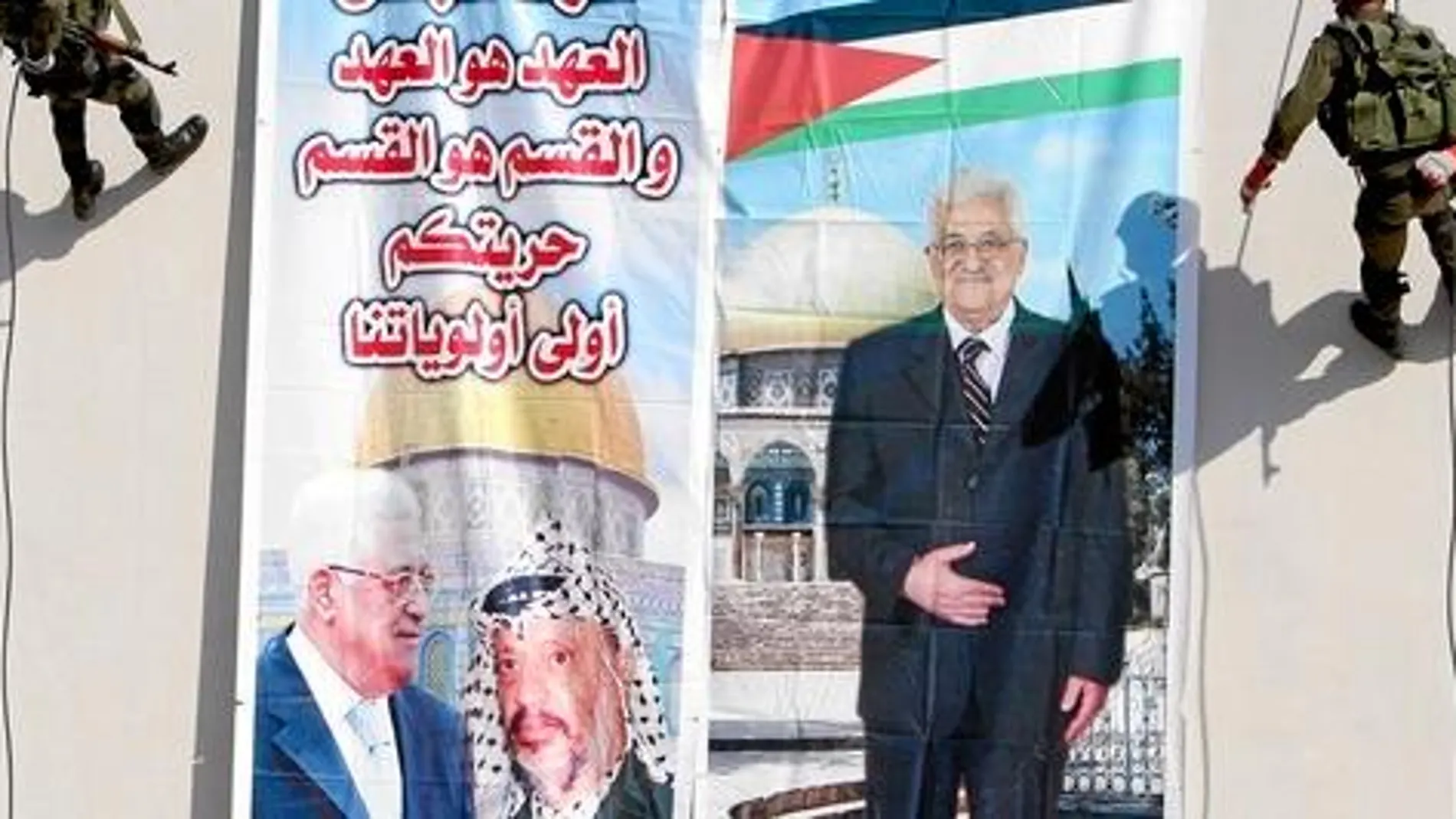 Mahmud Abas espera ganar popularidad con la operación en la ONU. Unos militares cuelgan ayer un cartel con su imagen junto a Arafat en Cisjordania