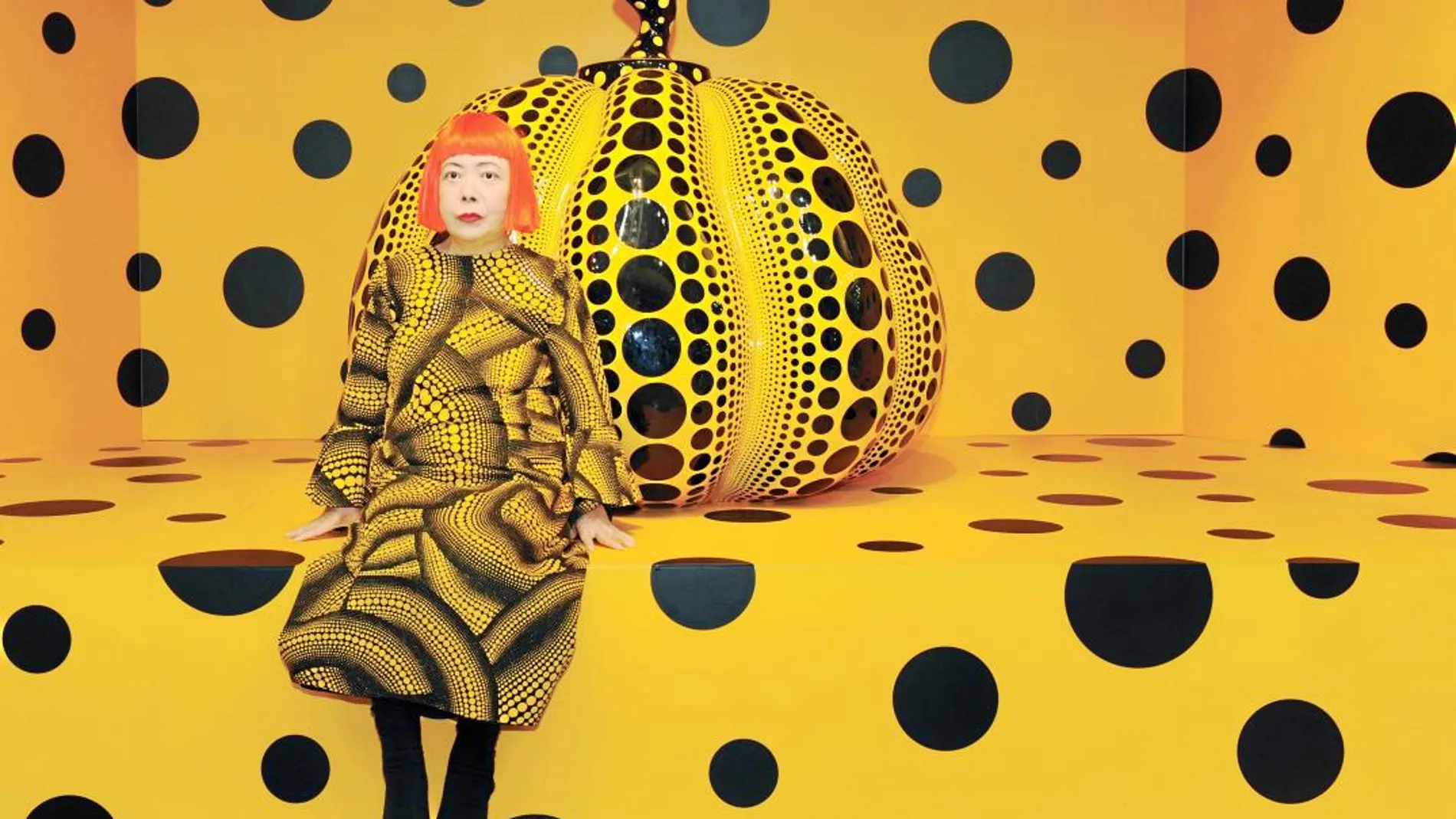 La artista japonesa Yayoi Kusama posa junto a una de sus instalaciones. Las calabazas y los círculos son parte de su seña de identidad