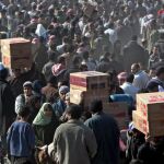 Palestinos cruzan el paso de Rafah, en la frontera entre la franja de Gaza y Egipto, para buscar abastecimiento