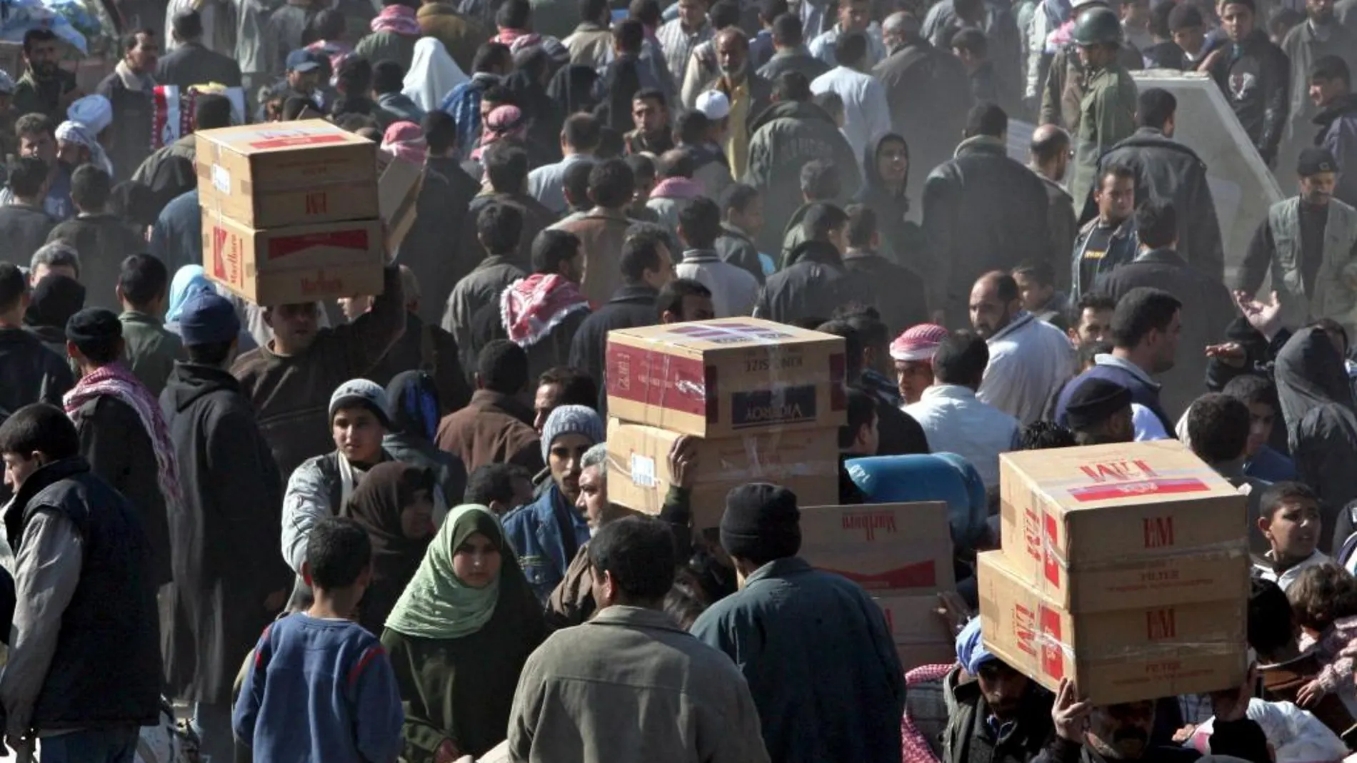 Palestinos cruzan el paso de Rafah, en la frontera entre la franja de Gaza y Egipto, para buscar abastecimiento