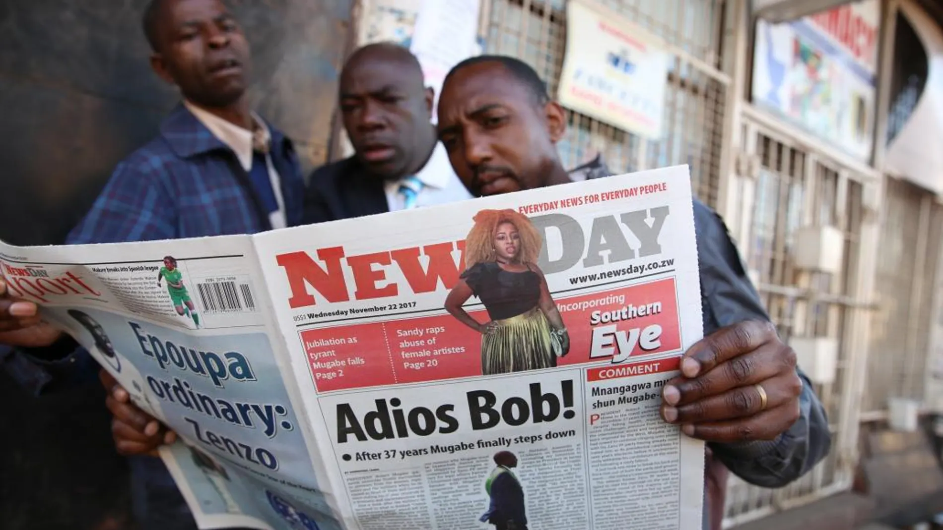 Tres hombres leen el periódico en una calle en Harare (Zimbabue), ayer