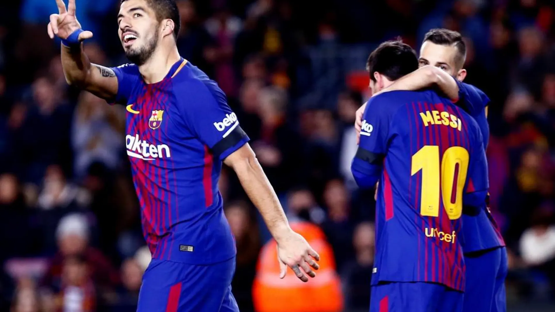 El delantero uruguayo del FC Barcelona Luís Suárez celebra su primer gol mientras el delantero argentino Leo Messi se abraza al defensa Jordi Alba (