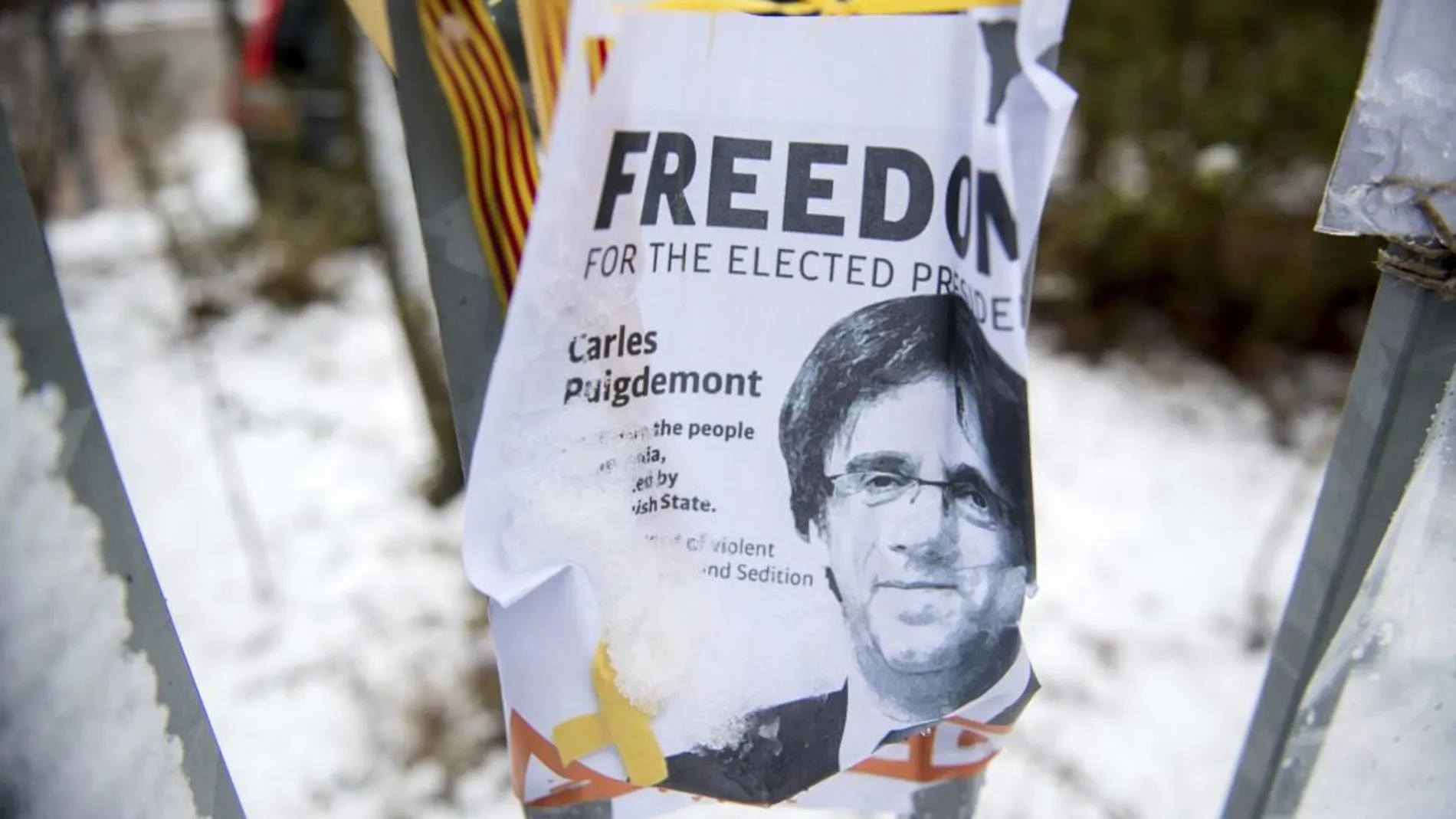 La imagen de un cartel pidiendo la libertad de Carles Puigdemont frente a una prisión alemana