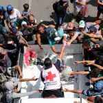 Personal de la Cruz Roja entrega agua a migrantes hondureños que continúan recorriendo otro tramo del territorio mexicano rumbo a su objetivo principal, Estados Unidos