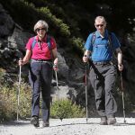 Mochila al hombro y bien equipados con bastones de senderismo, Theresa May y su marido disfrutan de un paseo