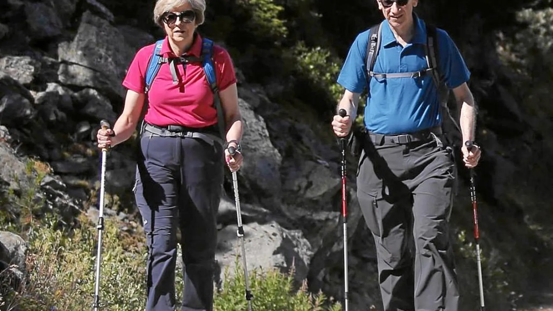 Mochila al hombro y bien equipados con bastones de senderismo, Theresa May y su marido disfrutan de un paseo
