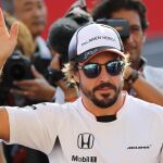El piloto español Fernando Alonso, del equipo McLaren Honda, saluda al público durante la tradicional firma de autógrafos previa al Gran Premio de Fórmula Uno de Japón